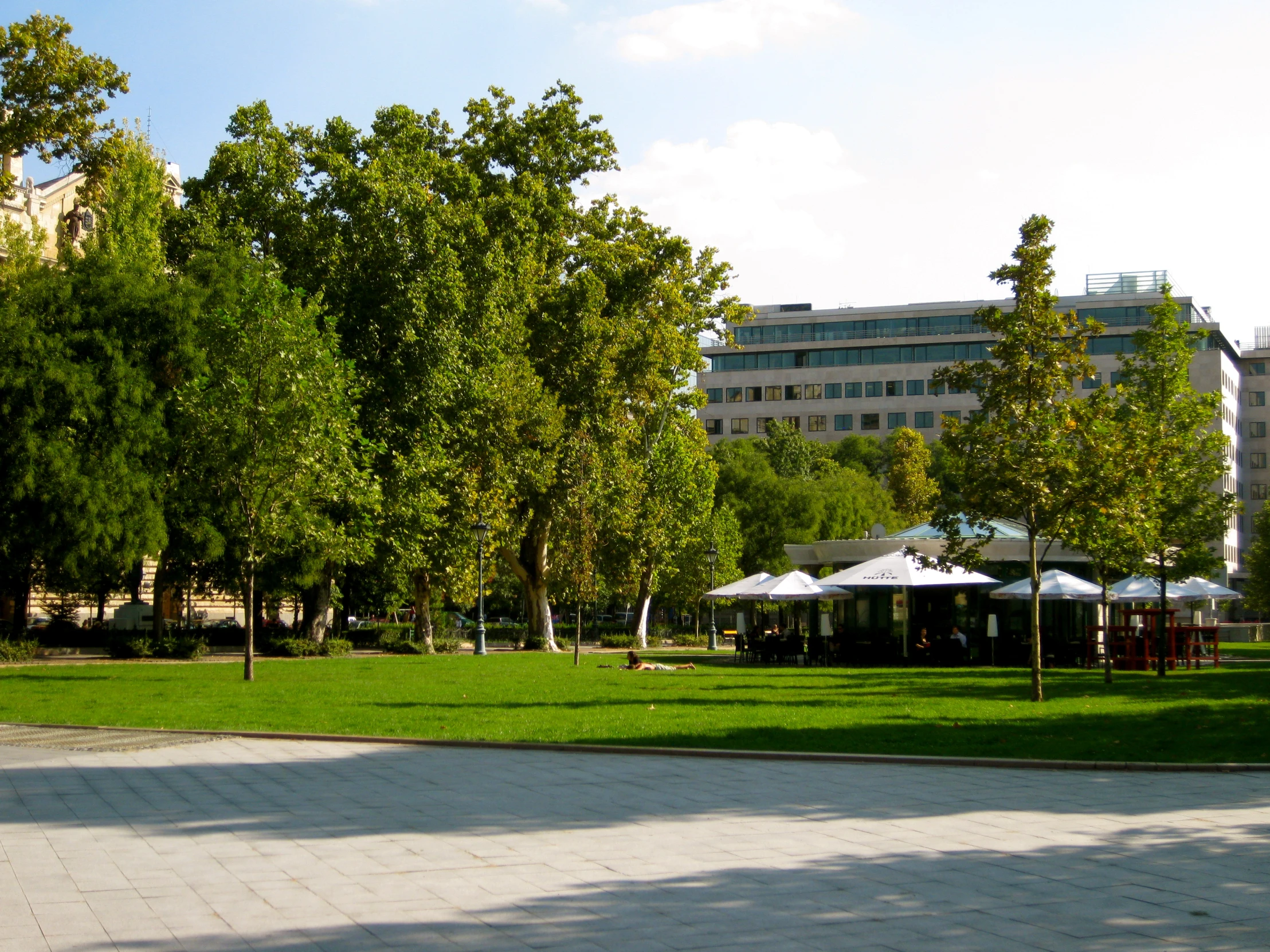 the view of the building, trees and benches