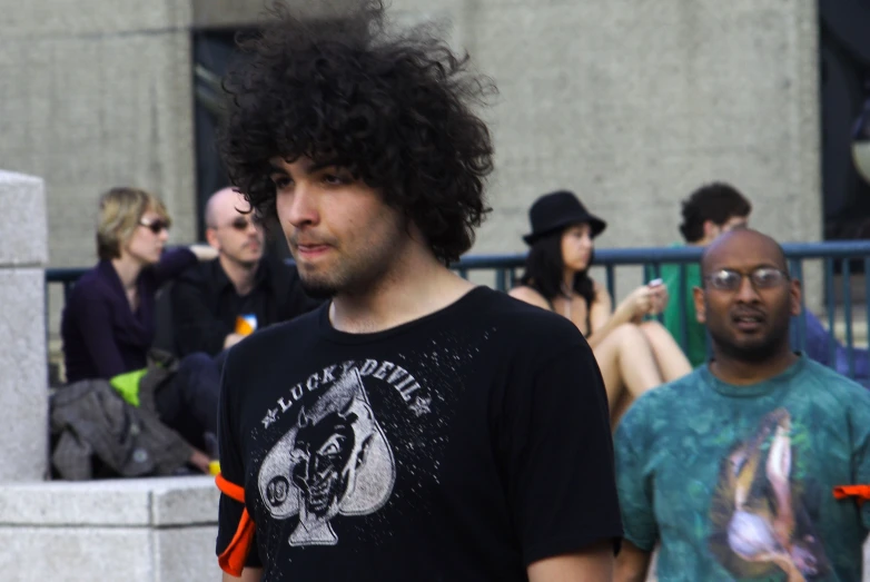 man in black shirt talking on cell phone near other people