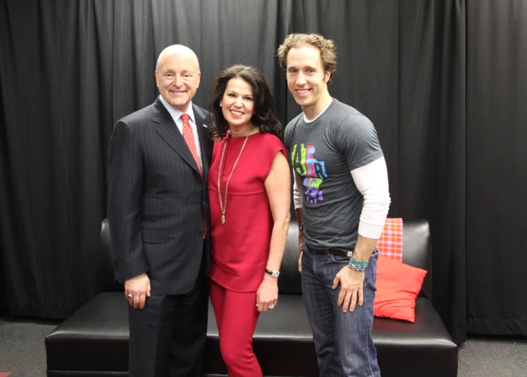 three people posing together on a bench at an event