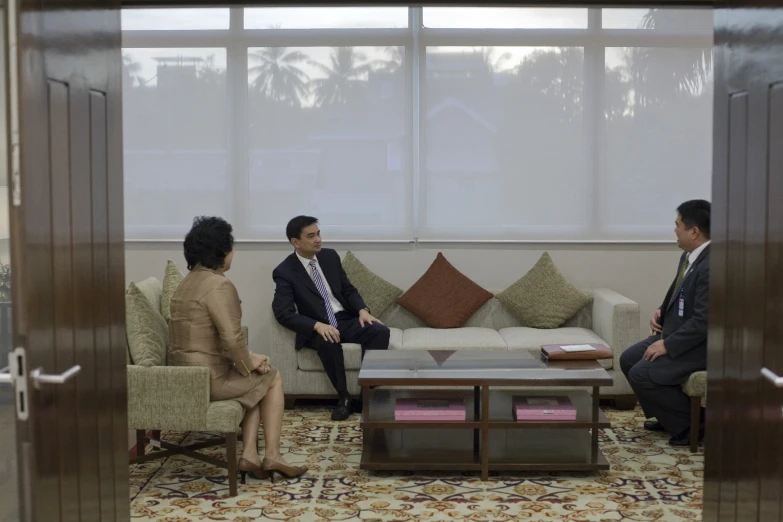 three people sitting on couches in a room