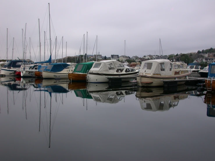 several boats that are in the water with buildings in the background