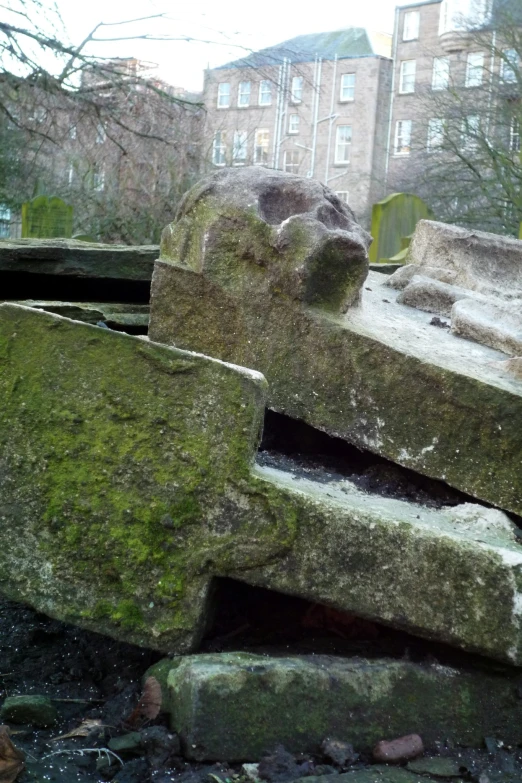 two stone sculptures in the rocks beside a building