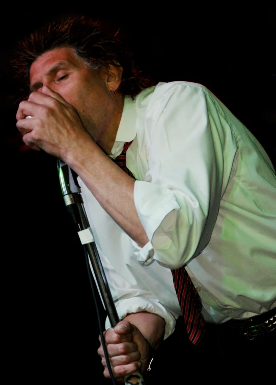 a man with his mouth open with his hands resting in the air while holding a microphone