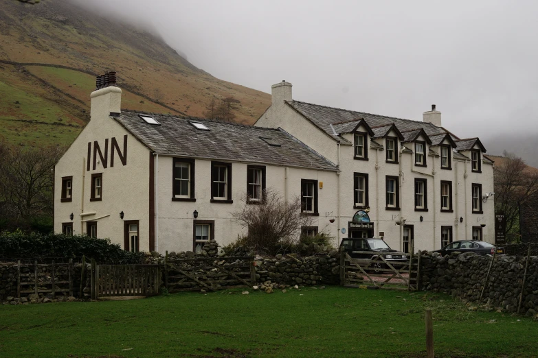 this large house has a mountain side behind it