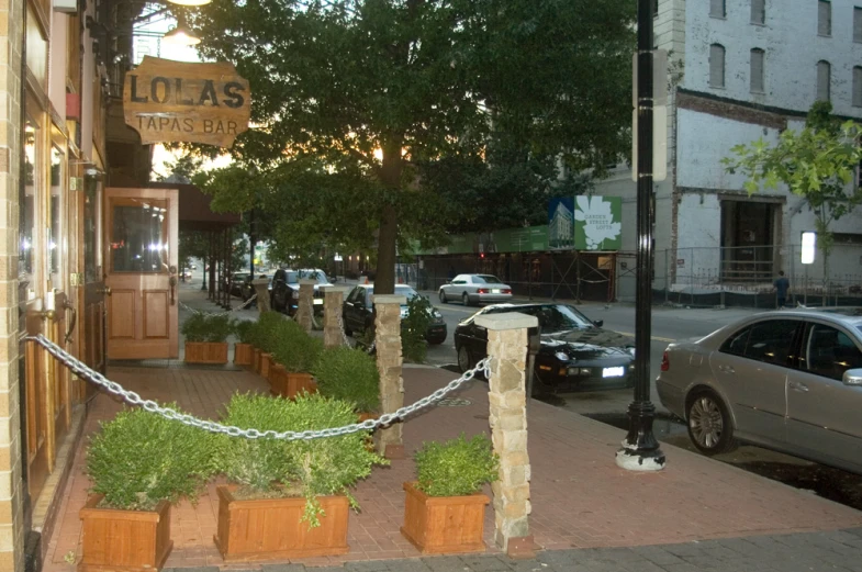 a sidewalk is shown with planters and parked cars on it