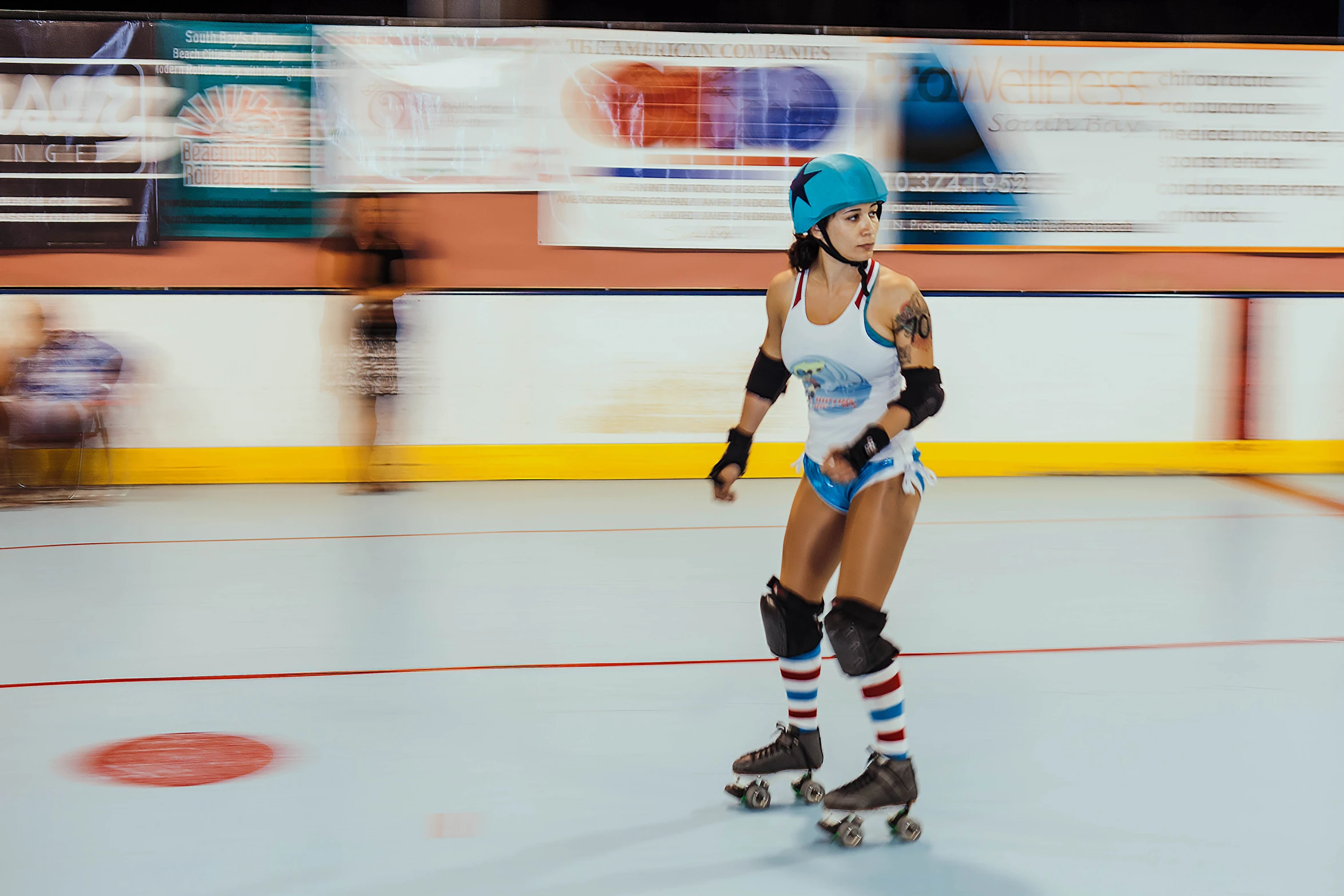 a woman on roller skates riding in an indoor rink