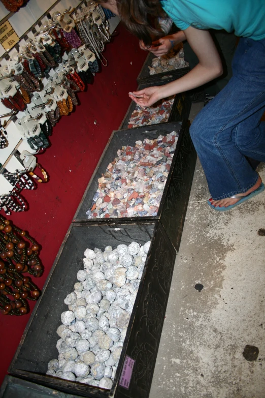 a person standing at a counter with three trays of ons