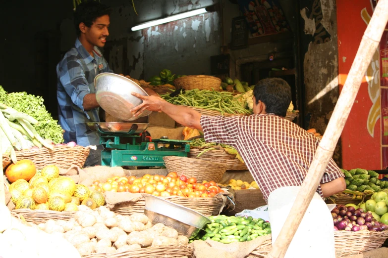 a man is in the marketplace preparing to sell fruits and vegetables