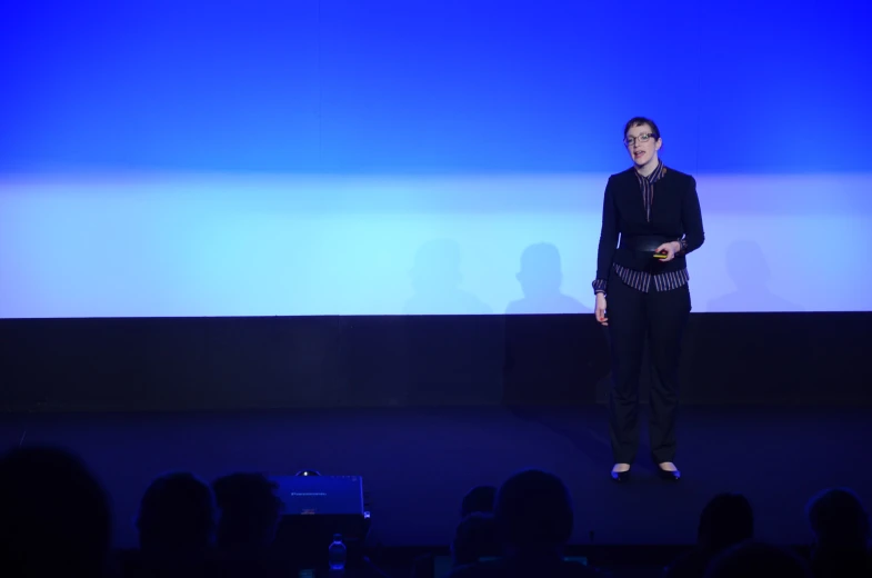 a woman standing on a stage in front of a screen