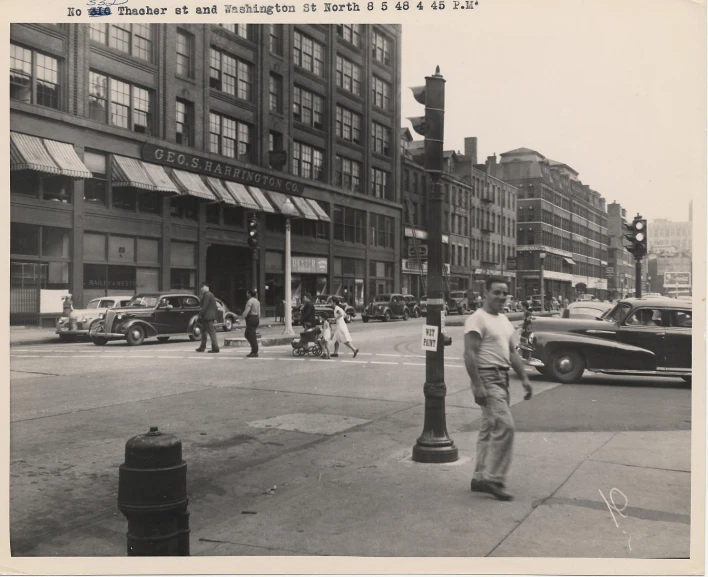 the old pograph shows a man walking in the city