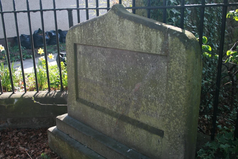 a cemetery with several graves, and an iron fence