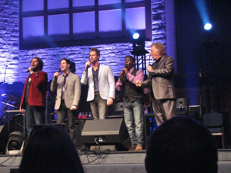 a group of people on stage holding microphones