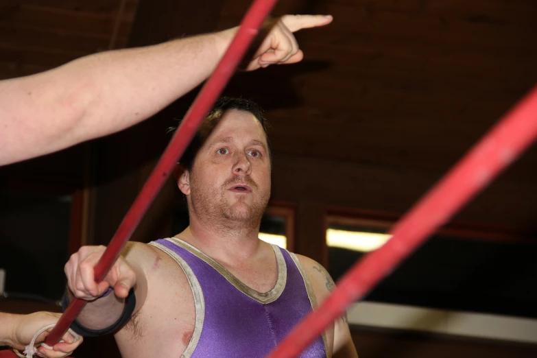 the man is playing with two red ropes in the gym