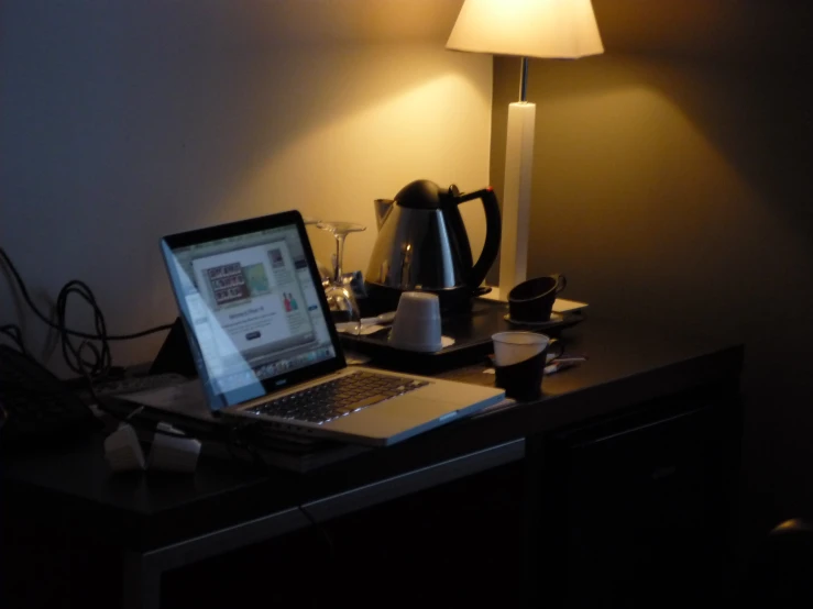 a laptop on a desk near the lamp