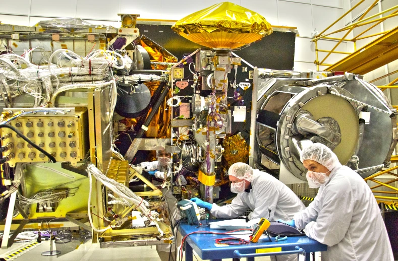 two people working on an object in a factory