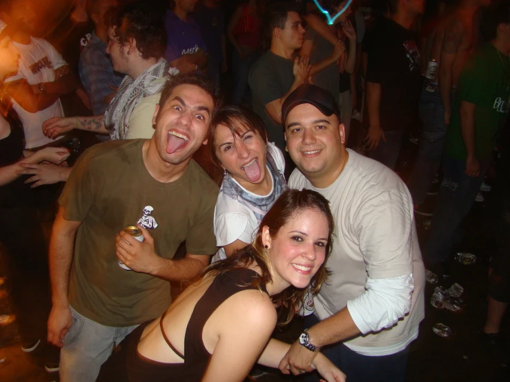 four smiling people with the tops down in a crowded bar