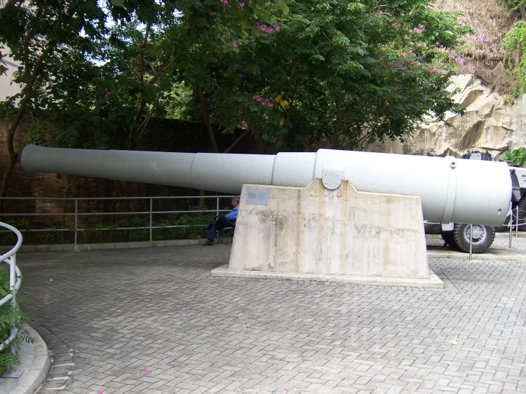 a large white cannon sitting on top of a cement slab