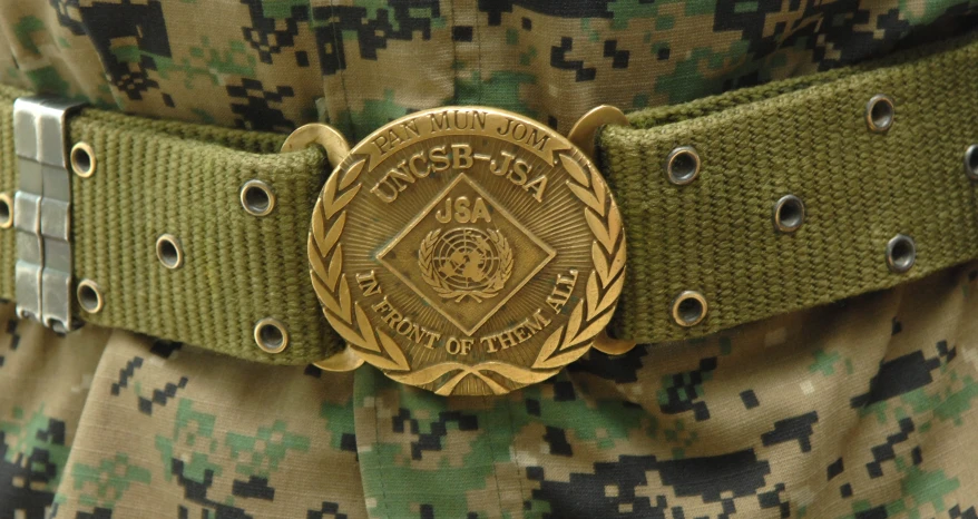 a military uniform is seen with two buckles