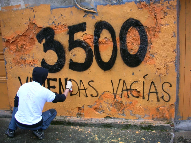 a person kneeling down in front of a wall