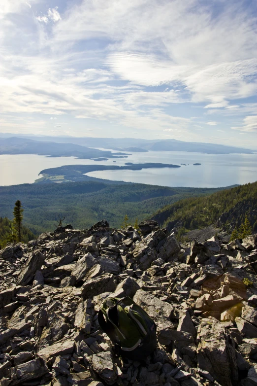 a view from a mountain of rocks and rocks with mountains and water in the background