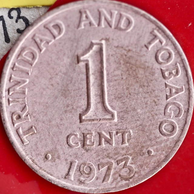 an one cent coin laying on top of a red table