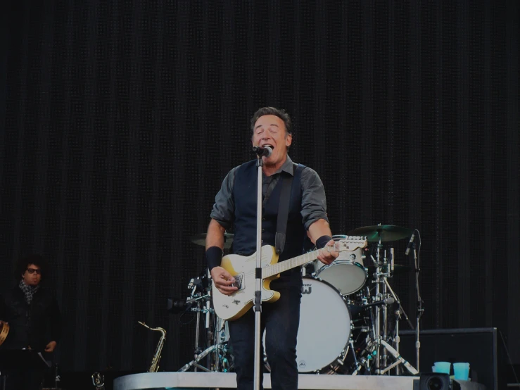 two men with guitars are performing in front of microphones