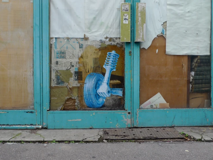 a broken door with a giant blue guitar painted on the side