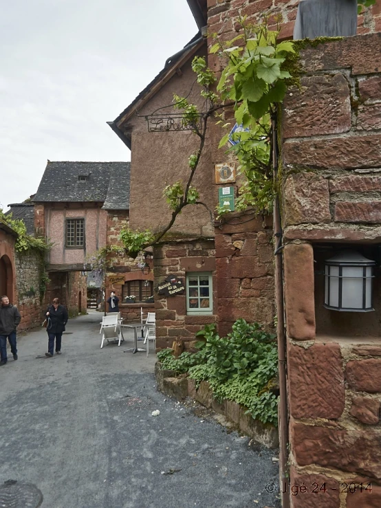 an old stone house sits next to a tall brick building