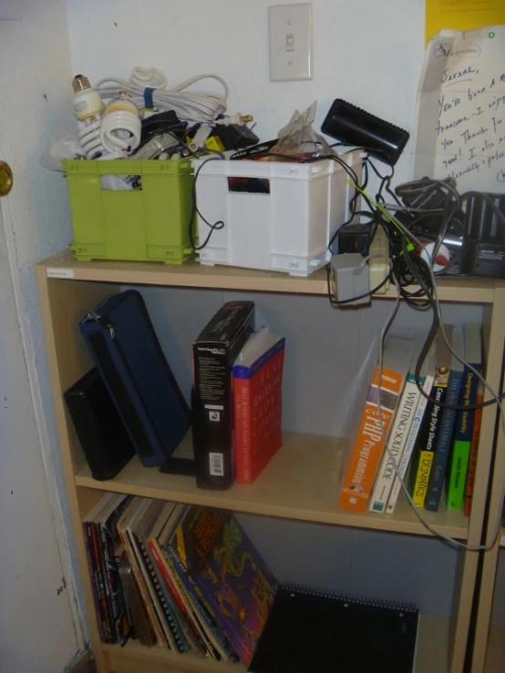 several books on a bookcase with a wire hooked to them
