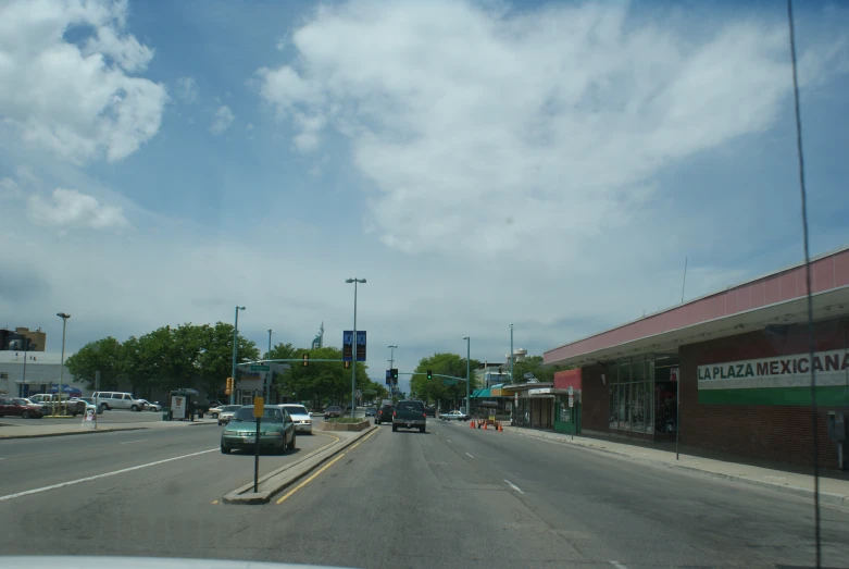 some cars driving down a small street in front of stores