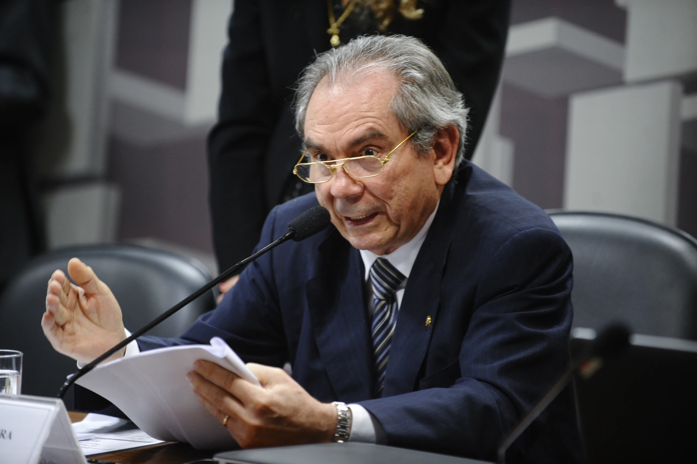 a man is sitting in a chair, holding up a piece of paper