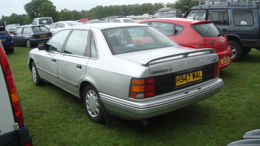 an older model car parked near other newer vehicles