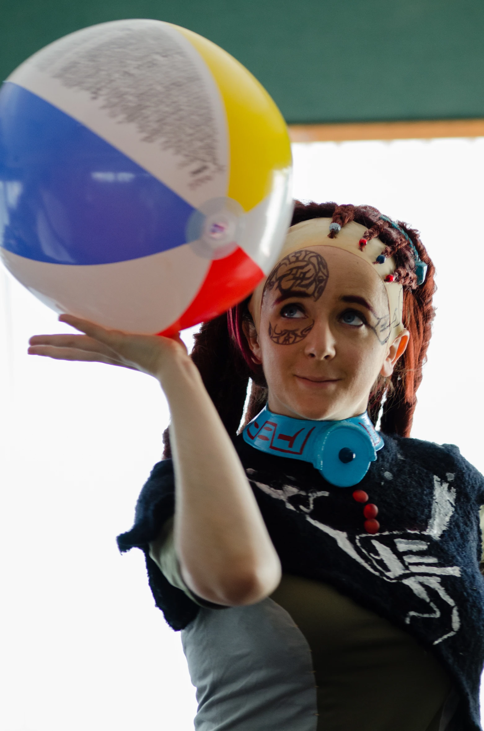 a lady holds up a colorful beach ball