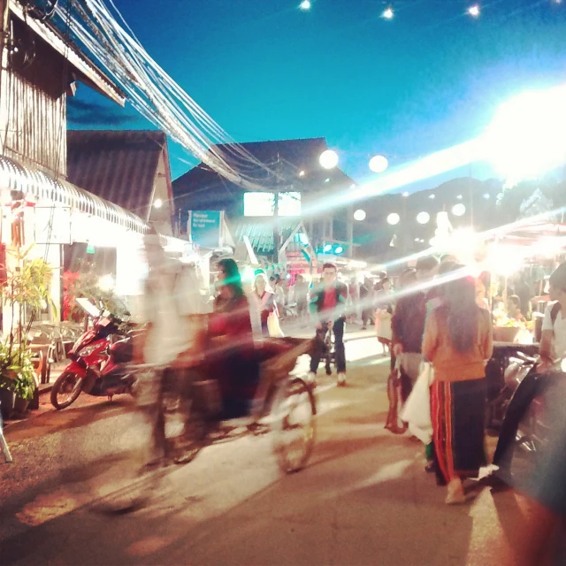 the lights are reflecting off of the people on the bikes