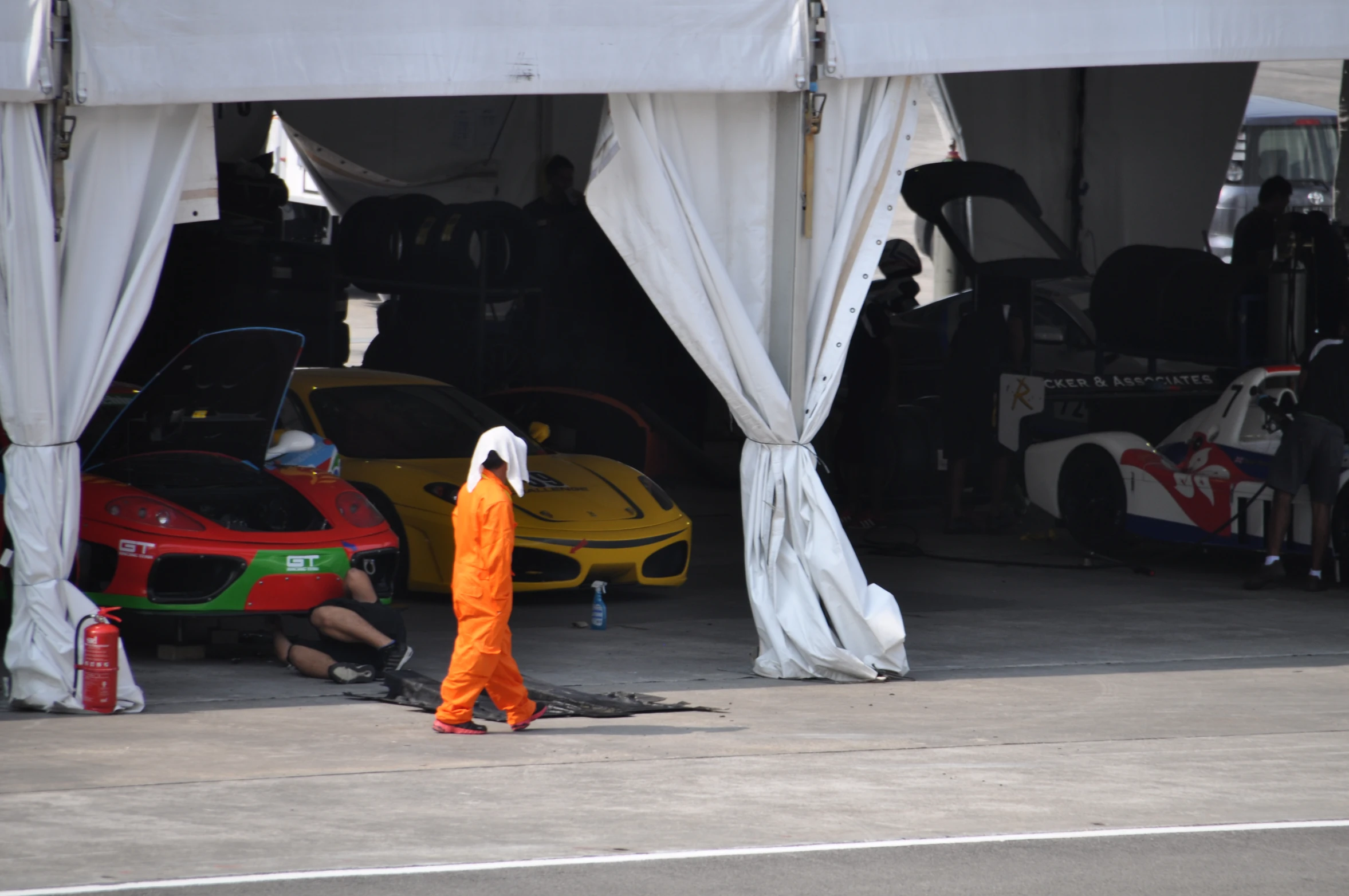 a man in an orange jumpsuit walking past some parked cars