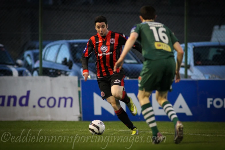 two men are playing a soccer game, and they are about to kick the ball