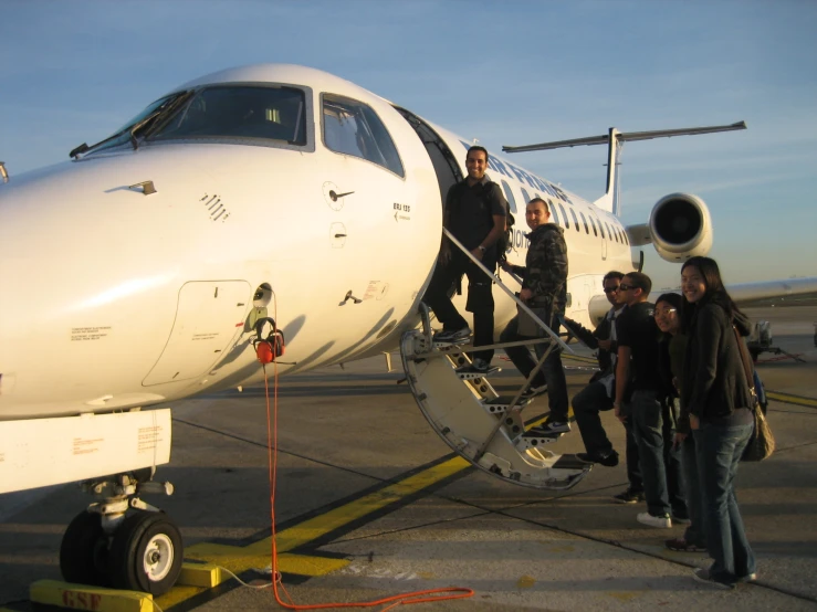 an airplane with people getting out and walking up to it