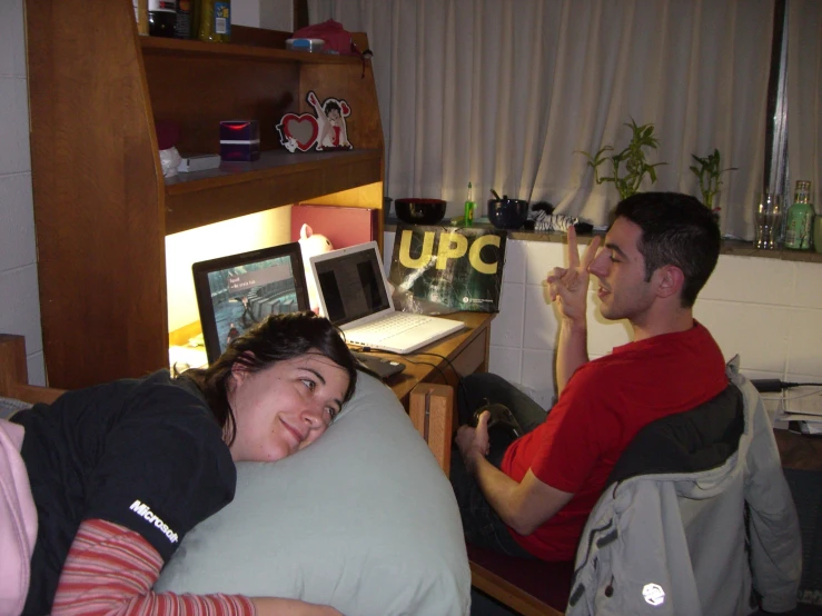 man and woman sitting next to each other in bed