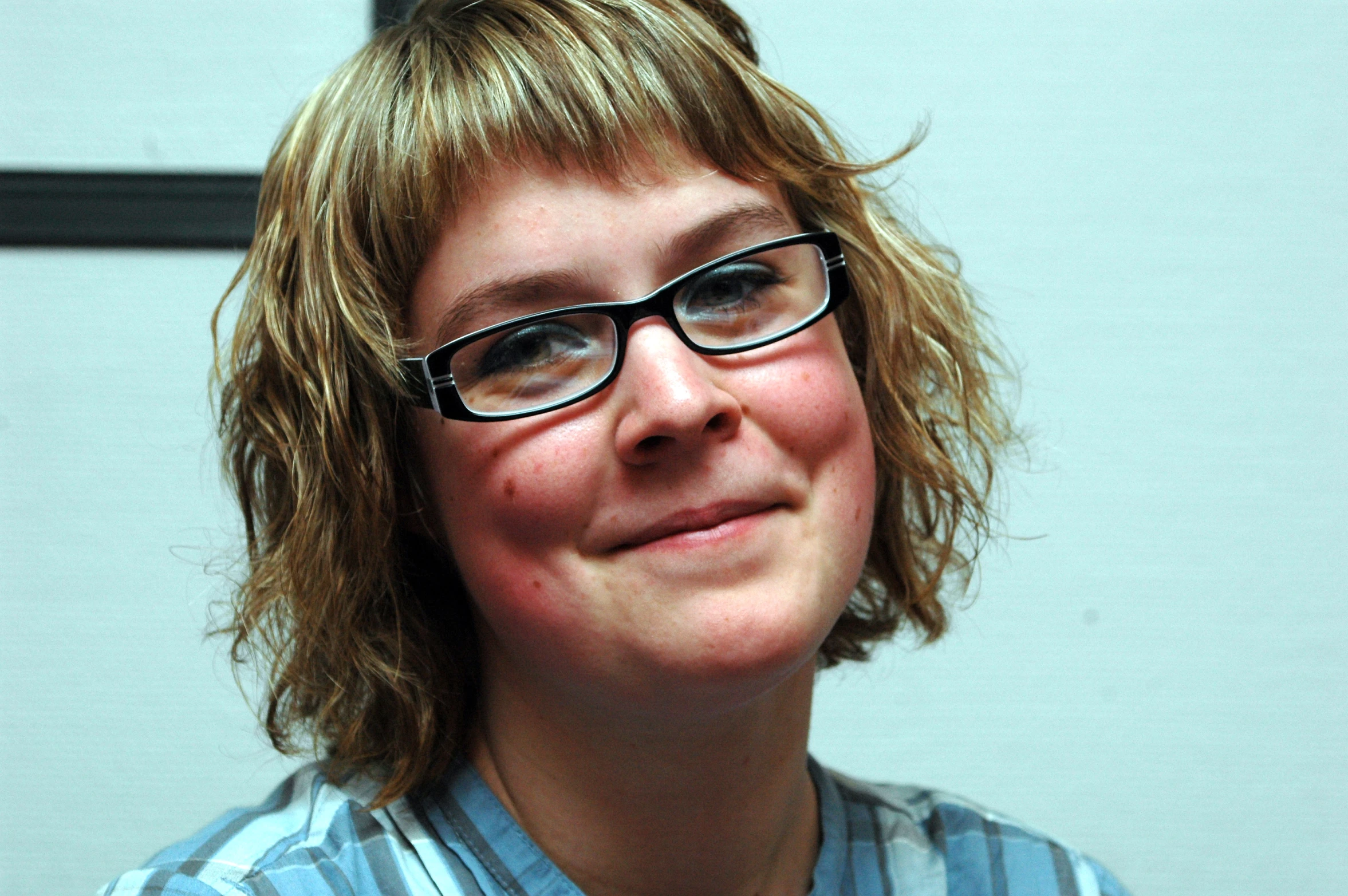 a woman is smiling and wearing glasses