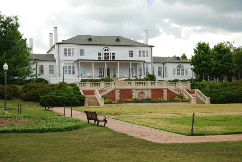 a couple of benches in front of a big house