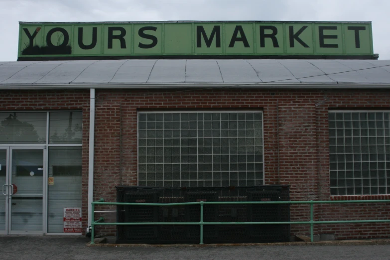 a green and white sign is on top of a brick building