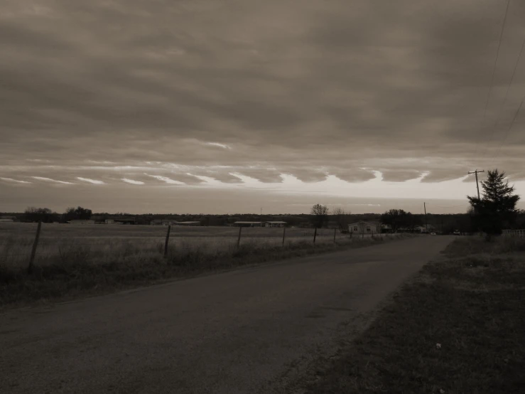 the sun is going down on an empty road