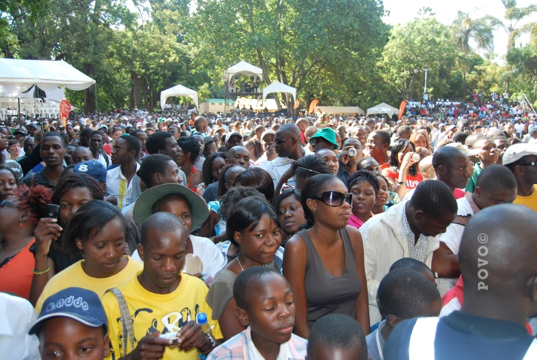 many people are gathered together near an umbrella