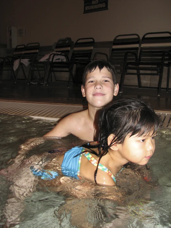 a child and an adult play in a large pool