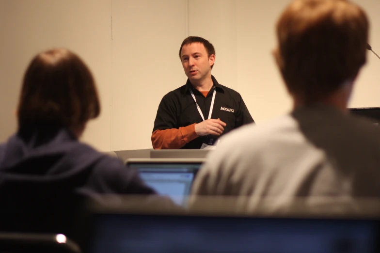 man making speech at business meeting in front of people