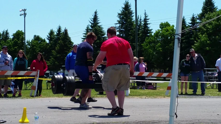 some men standing on the side of a road and a person in red shirt and tan pants