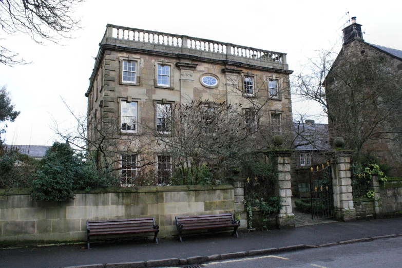 three empty benches sitting outside an old building