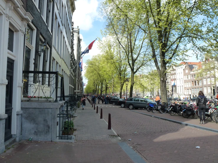 street with parked cars in the front with a lot of people