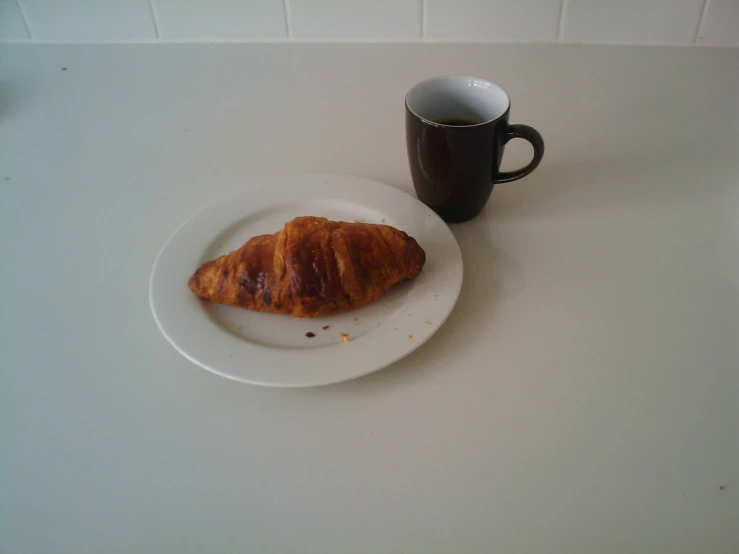 an apple croissant with a coffee mug sits on a table