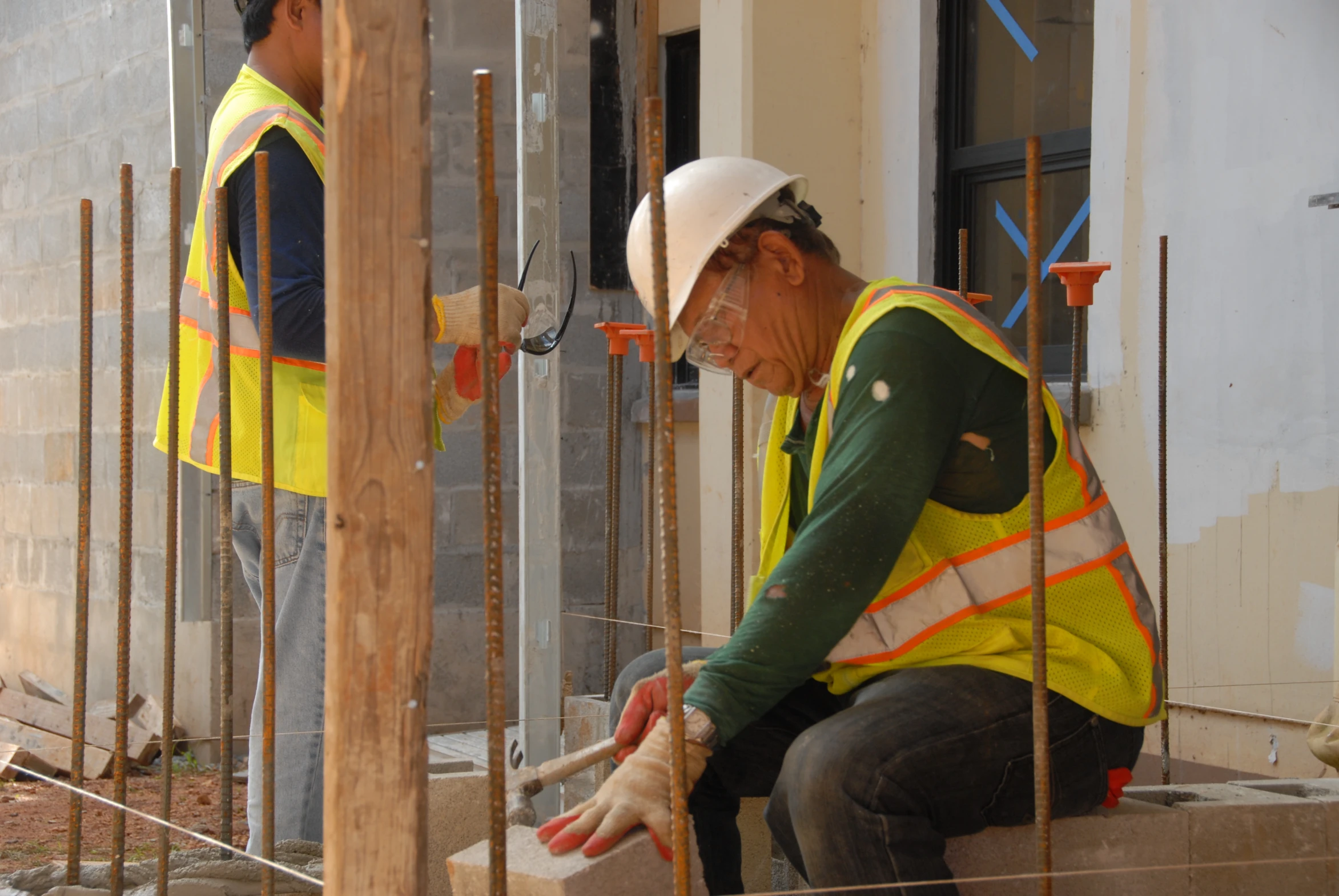 two construction workers working on building flooring